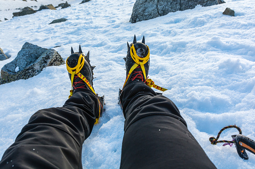 Stary Smokovec, Slovakia - May 01, 2023: Crampons on boots required equipment for hard frozen snow on steep slopes in the mountains.