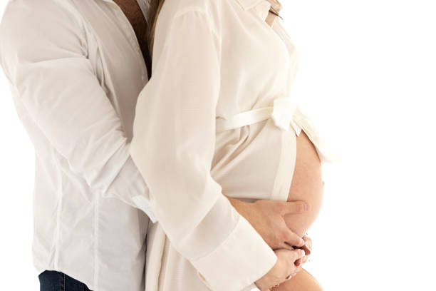 Belly of pregnant woman with hands of mom and dad