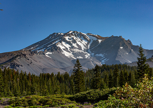 Hiker enjoys view at Mount Baker and Iceberg Lake, on the Chain Lakes Loop trail in Washington state, USA.