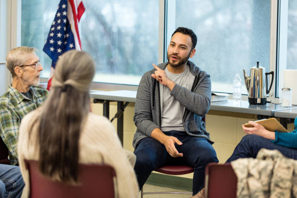 istock Young man gestures and shares with diverse veteran support group 1487109724