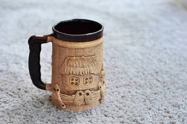A large cup of dark color with a pattern