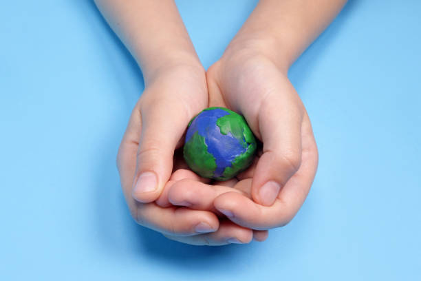 istock Child's hand holding plasticine planet earth, ecology concept 1487115798