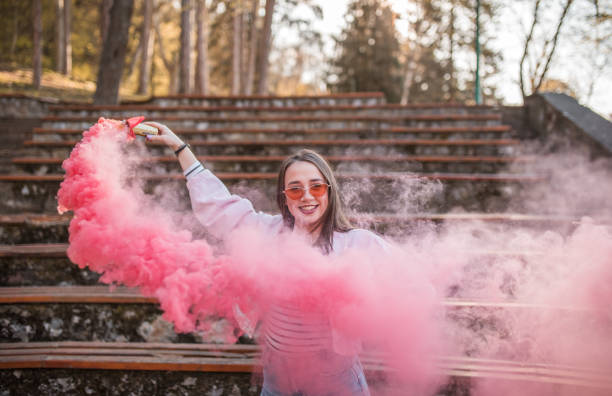 istock Smiling woman holds a burning torch in her hands while standing in the park and having fun 1487116609
