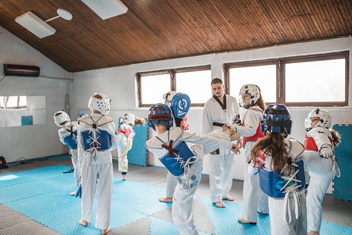Taekwondo training in sport hall with tatami. Taekwondo is equally popular sport among girls and boys, young men and women