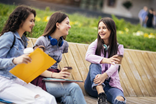 istock Group of collage students sitting on bench and studying for school 1487125891