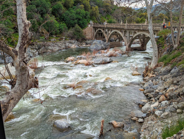 Rapids on the Kaweah River in Three Forks California by historic bridge built by the CCC showing heavy snow runoff from Mineral King and Sequoia National Park in April 2023