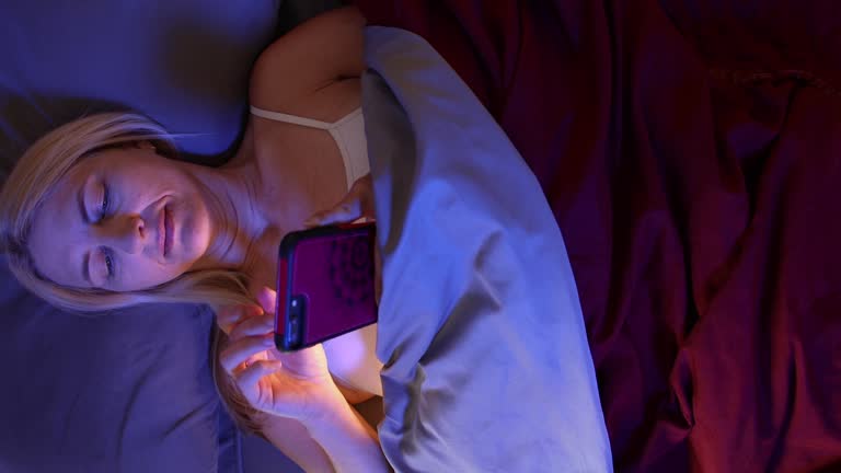 Woman in Bed Using Cell Phone