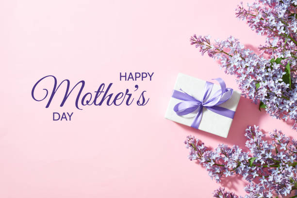 istock Flat lay happy mothers day frame with lilac branches and gift box on a pink background 1487128367