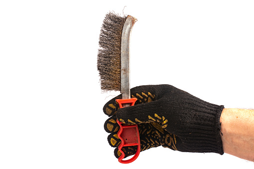 A man's hand with metal wire brush isolated. A hand holding a wire brush.Tools fof welding. Wire brush for cleaning.