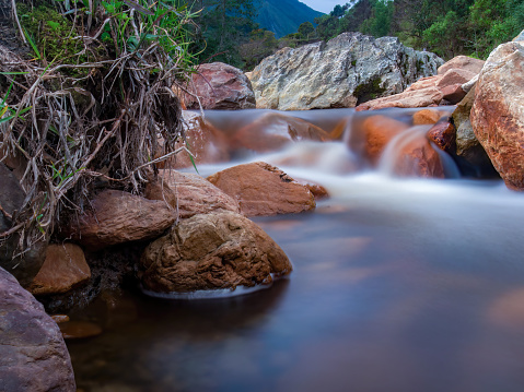 Long-exposure photography of the stream and rocks of Del Valle river, near the town of La Palma in the central Andean mountains of Colombia.