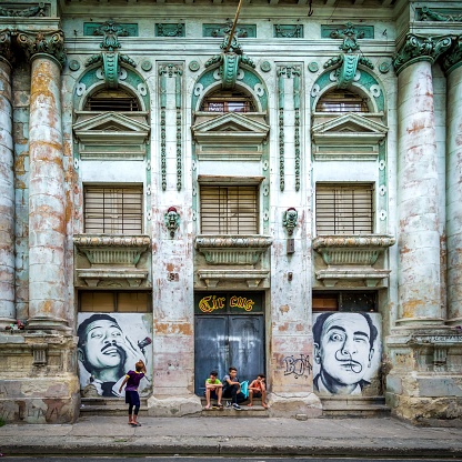 Havana, Cuba – June 20, 2018: Four children playing in front of an old building with some graffities, the architecture remains a building with columns and windows with ornaments