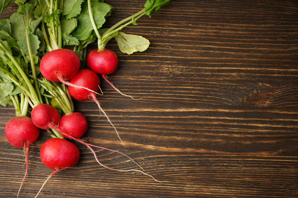 istock Fresh red radish on wooden background, space for text. Top view. 1487138939