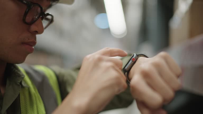 Warehouse worker using smartwatch.