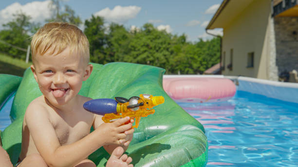 istock PORTRAIT: Little boy ready for water fight game while floating in swimming pool 1487141478