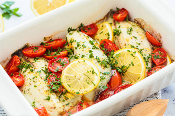 istock Baked cod fillet with cherry tomatoes and butter. 1487143581