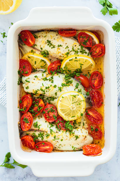 istock Baked cod fillet with cherry tomatoes and butter. 1487143598