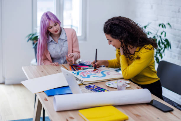 istock Two women painters are working in a home studio using aquarelle colors. 1487145433