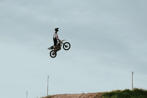 Extreme sports, motorcycle jumping. Motorcyclist makes an extreme jump against the sky