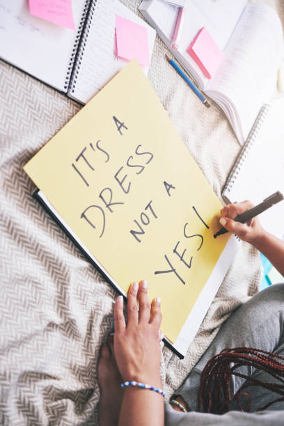 istock Woman activism, writing and sexual assault protest message for bold and angry statement poster. Girl sharing opinion and thought about rape problem with frustrated, protesting words on paper. 1487147724