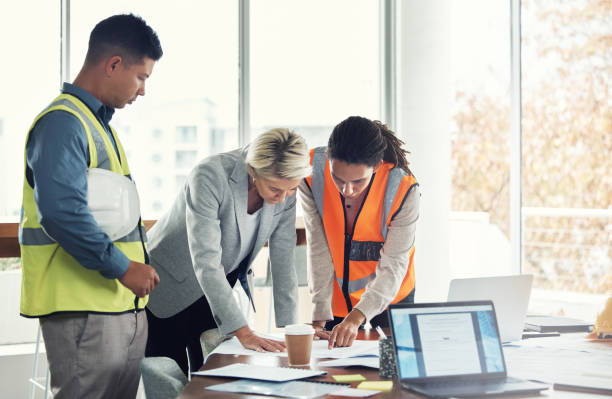 istock Architecture, collaboration and planning with people and blueprint in office for construction, design and building. Teamwork, review and meeting with group for project management, goal or engineering 1487148690