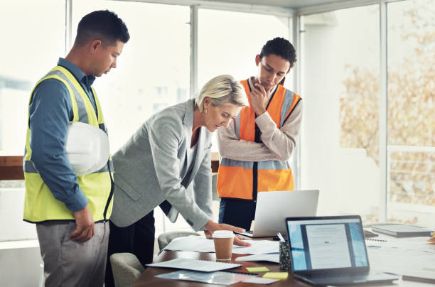 istock Engineering, teamwork and planning with blueprint in office for construction, designer and building. Collaboration, review and meeting with group of people in architecture project management and goal 1487148691