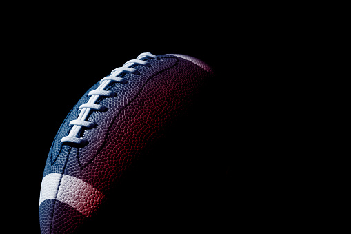 American football ball close up on black background. Horizontal sport theme poster, greeting cards, headers, website and app
