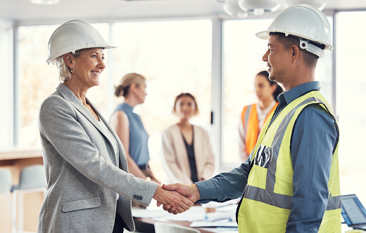 Collaboration, happy and engineering with handshake of people in office for architecture, b2b or contract. Partnership, meeting and shaking hands with employee for designer, construction or agreement