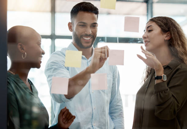 istock Writing, post it and innovation vision schedule for teamwork, planning and company growth strategy. Smile, happy or creative business people with diversity and research glass wall for brand analytics 1487152003