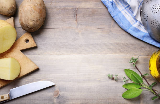 Wooden background  with potatoes, space for text, top view.
