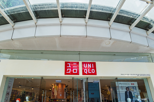 Uniqlo Store front with sign and logo in Kuala Lumpur, Malaysia. Uniqlo is a Japanese casual wear designer, manufacturer and retailer, a wholly owned subsidiary of Fast Retailing