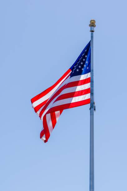 istock Vivid American flag fluttering against a clear blue sky 1487155915