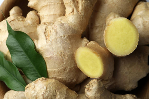 Fresh ginger with leaves in bowl, top view Fresh ginger with leaves in bowl, top view ginger stock pictures, royalty-free photos & images