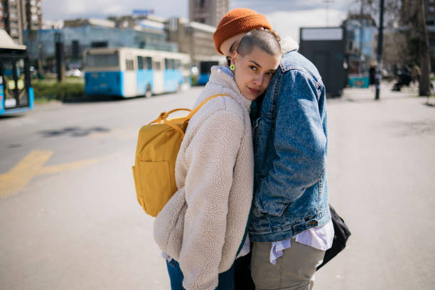 Female friends greeting each other good bye with a hug outside in the city Female friends greeting each other good bye with a hug outside in the city. Two women couple greet at the train station before leaving for vacations. lesbian couple embracing stock pictures, royalty-free photos & images