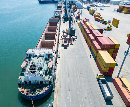 Brightly coloured containers are loaded onto a huge ship by cargo cranes at the Port of Los Angeles.