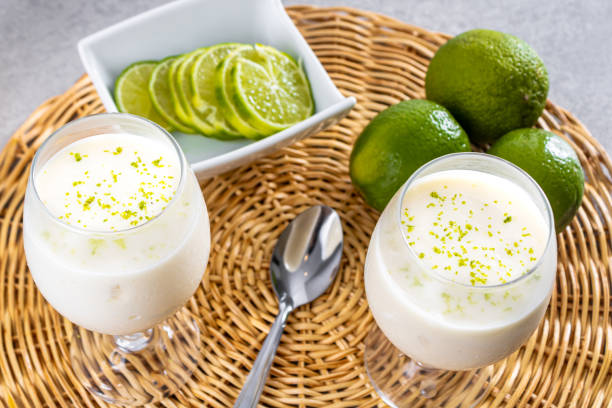 istock Delicious lemon mousse on a straw plate and a white table background, with whole and sliced lemons in the background, and a metal spoon 1487169007