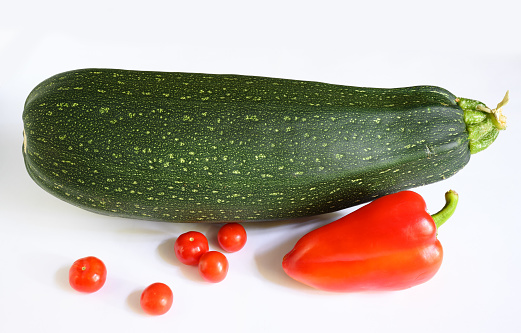 Vegetable marrow zucchini and sweet pepper isolated on white background. Photography of one fresh squash, top view. Theme of zucchini, organic food, nature.