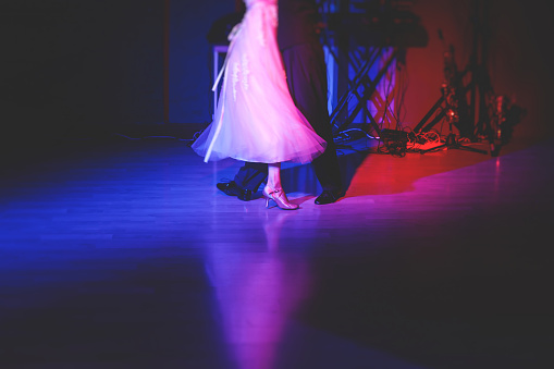 Couples dancing traditional latin argentinian dance milonga in the ballroom, tango salsa bachata kizomba lesson in red and purple lights, dance school class festival