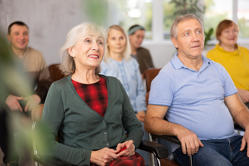 Older male and female students listening to lecture in university