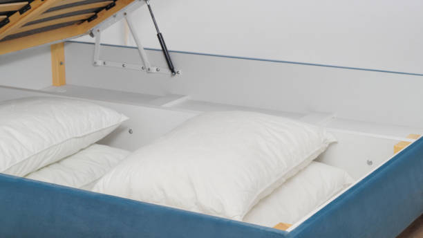 istock Storage drawer under bed with white pillows indoors, closeup 1487173153