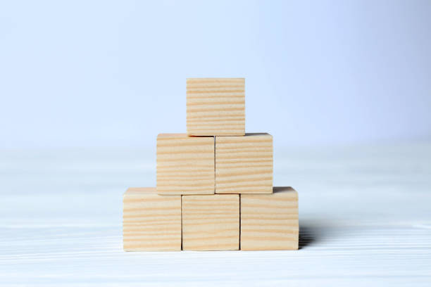 istock Pyramid of cubes on wooden background, space for text. Idea concept 1487173211
