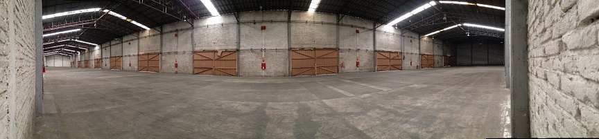 Panorama view of naturally lighted warehouse clear space