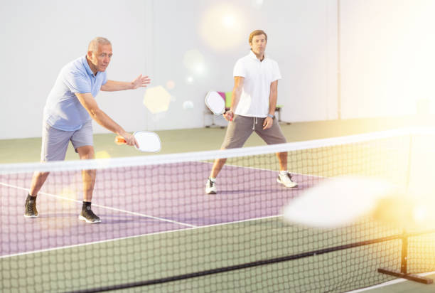 istock Aged man playing doubles pickleball match with male partner 1487175496