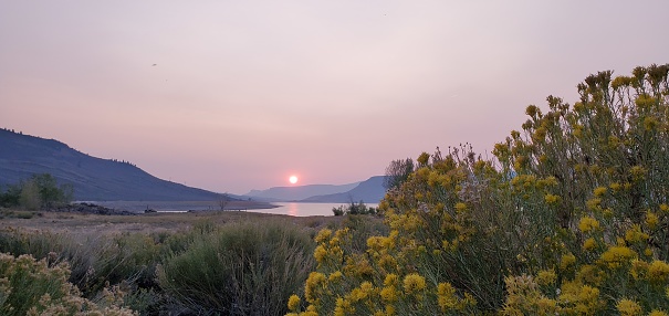 This is a photograph taken on a mobile phone outdoors at sunset with smoke in the sky at Curecanti National Recreation Area in Gunnison, Colorado during autumn of 2020.