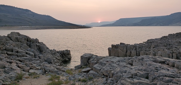 This is a photograph taken on a mobile phone outdoors at sunset with smoke in the sky at Curecanti National Recreation Area in Gunnison, Colorado during autumn of 2020.