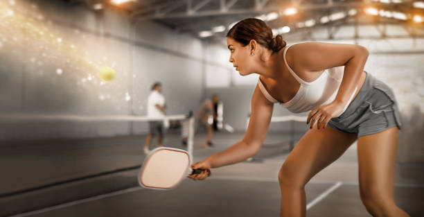 コート上のピックルボールゲームでラケットでボールを跳ね返す若い女性 - tennis indoors women court ストックフォトと画像