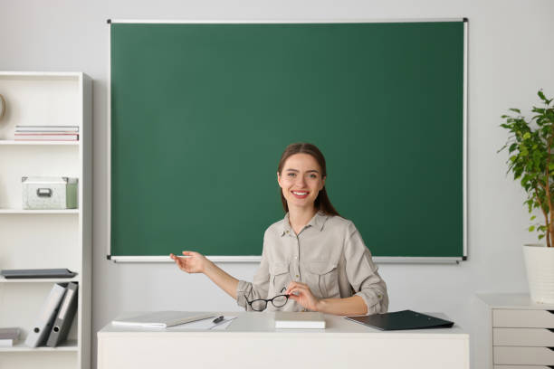 istock Beautiful young teacher giving lesson at table in classroom 1487178815