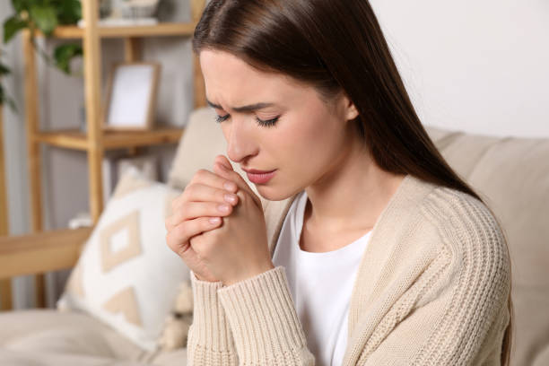 istock Woman with clasped hands praying at home 1487178850