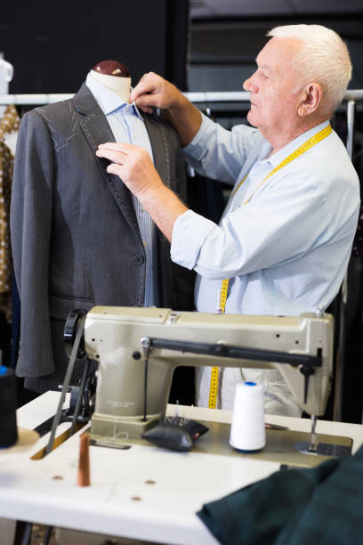 istock Experienced tailor tries on a new jacket on a mannequin in sewing atelier 1487182824