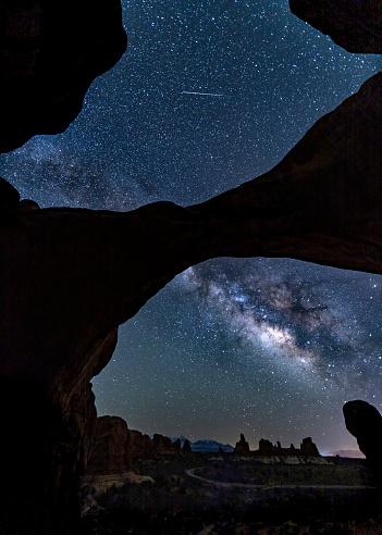 A metero streaks above te Mily Way as it threads throguh iconic Double Arch in Arches National Park near Moab, Utah.