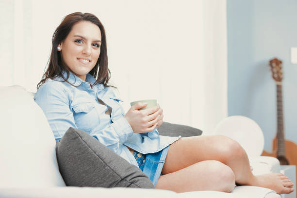 istock Blue denim outfit and green mug in hand 1487184182